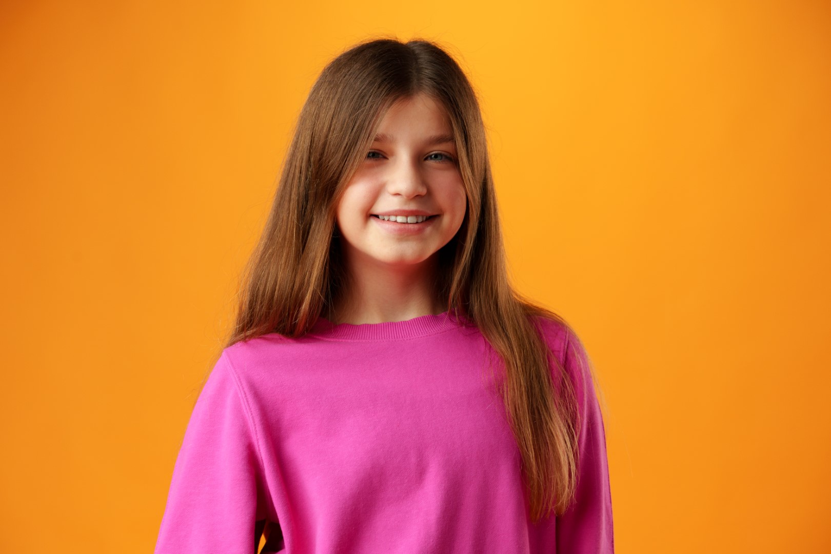 Photo of teen girl smiling portrait against yellow background in studio