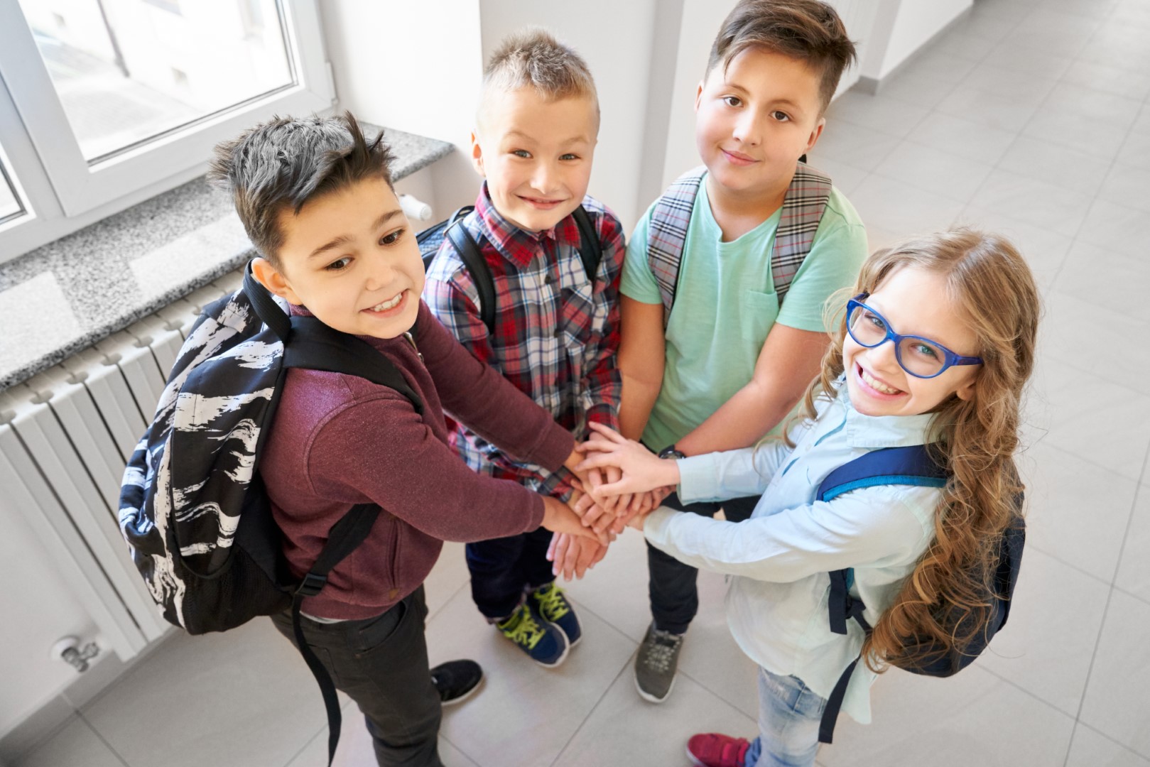 Pupils holding hands together under each other.